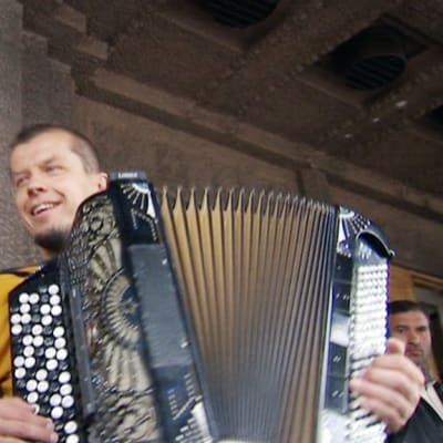 Kimmo Pohjonen soittaa romanien kanssa kadulla Helsingissä.