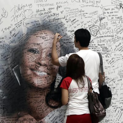Whitney Houstonin fanit ovat kirjoittaneet viestejä hänen muistokseen pystytettyyn suureen valokuvaan.