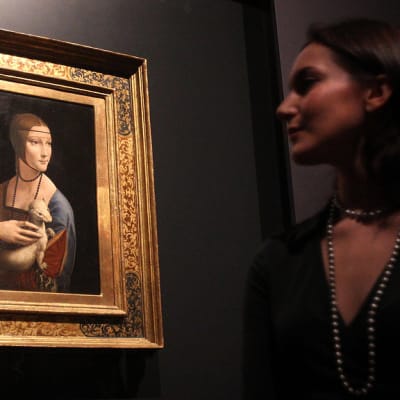 Galleriatyöntekijä katselee Leonardo da Vincin maalaamaa Cecilia Galleranin muotokuvaa.