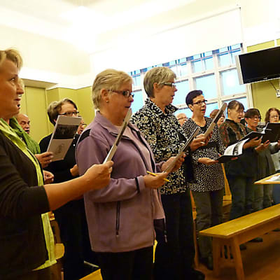 Sekakuoro johtajineen harjoittelee