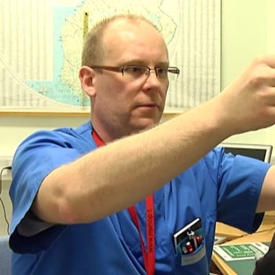 Vuoden Unihoitaja Markku Keski-Rahkonen sovittaa potilaalle ylipainemaskia.