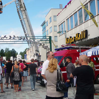 Kuvassa väkeä Pietarsaaren kesäisellä kävelykadulla, taustalla pelastuslaitoksen nosturiauto