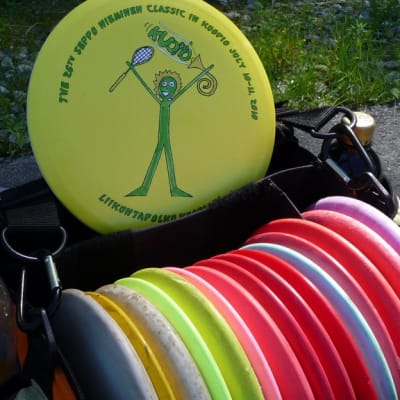 Frisbeegolfharrastajan kassista löytyy erilaisia kiekkoja riittämiin.