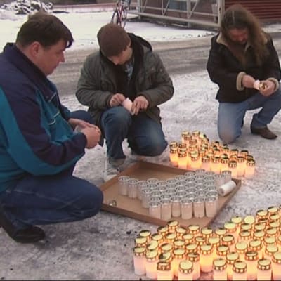 Kuitu Finland Oy:n hautajaisissa Valkeakoskella irtisanotut työntekijät sytyttävät hautakynttilöitä.