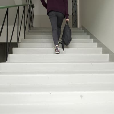 Nuori nainen kävelee ylös portaita.