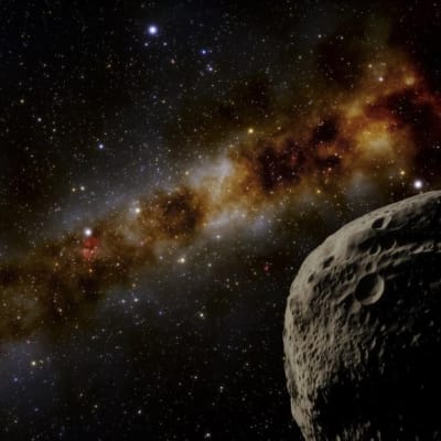 Kuoppainen kivimurikka pimeässä avaruudessa, taustalla muita avaruuden kohteita ja kaukana loistava Aurinko. 
