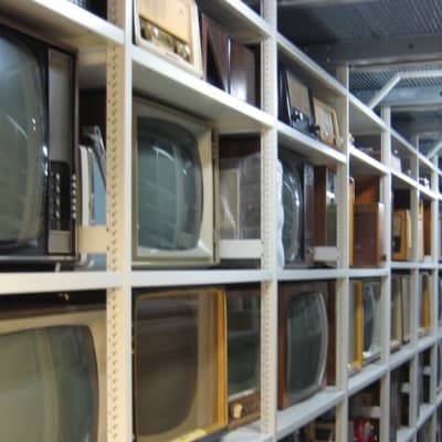 Vanhoja televisioita hyllyssä.