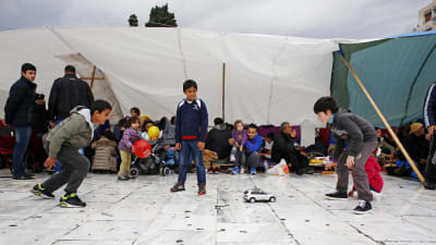 Syriska barn leker på Syntagmatorget framför parlamentshuset.