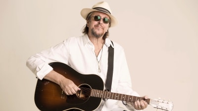 Heikki Harma, a.k.a. Hector sitter med en gitarr i famnen.