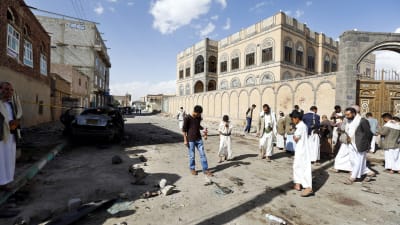 Människor inspekterar platsen i Sanaa där brutala självmordsattacker inträffade den 20 mars 2015.