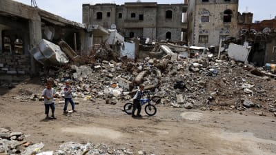 Förstörda hus och barn som promenerar bland husras. Barn promenerar i Sanaa den 3 augusti bland förstörda hus efter luftanfall från den saudiledda koalitionen