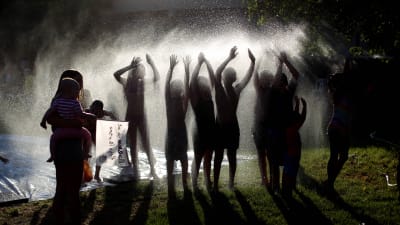 Israeliska barn leker med vatten på en kibbutz