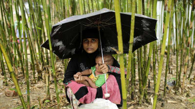 En rohingyaflykting har tagit skydd under ett paraply med sin baby i flyktinglägret Thangkhali, Coxbazar, Bangladesh 12.10.2017.