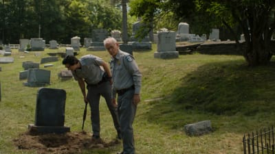 Bild från filmen "The Dead Don't Die" där skådespelarna Bill Murray och Adam Driver inspekterar en öppen gravplats.