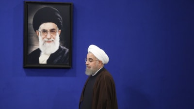Ett arkivfoto på president Hassan Rouhani då han passerar ett porträtt av Irans högste ledare Ayatolla Ali Khamenei. 