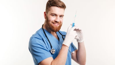 Leende manlig sjukskötare med sputa