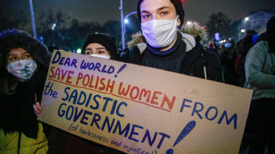 En person håller upp plakat under demonstration i Polen.