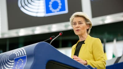 EU-kommissionens ordförande Ursula von der Leyen står i talarstolen. På sig har hon en gul kavaj och en svart blus. 