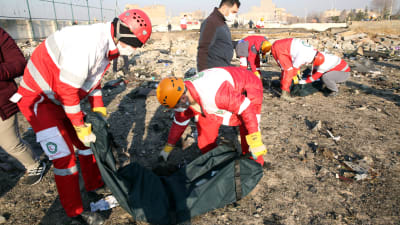 Kansainvälisen Punaisen puolikuun työntekijät tutkivat koneen jäänteitä keskiviikkona onnettomuuspaikalla.