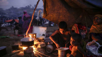 Två barn äter under under en presenning i ett flyktingläger i Ukhiya, Bangladesh, lördagen 16.9.2017.