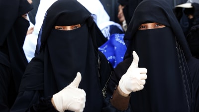 Två kvinnor i Jemens huvudstad Sanaa visar tummen upp för planerade fredssamtal i Sverige den här månaden  
