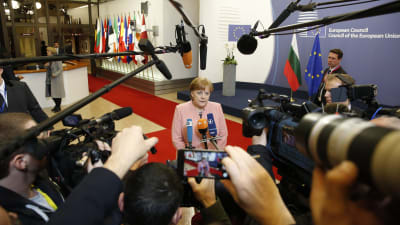 Tysklands förbundskansler Angela Merkel omringad av journalister i Bryssel.