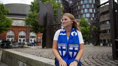 Kvinna i finska blåvita supporterfärger.