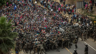 Guatemalanska soldater tog till käppar, batonger och tårgas för att tvinga tillbaka honduranska migranter vid en vägspärr i staden Chiquimuta på söndagen. 