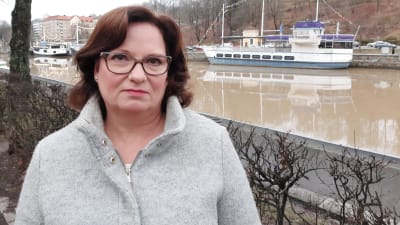 Mörkhårig kvinna vid åstranden i Åbo.