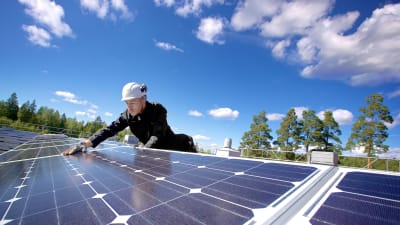 Forskningsassistenten Miguel Lavado installerar solpaneler på taket till Villmanstrands tekniska universitet
