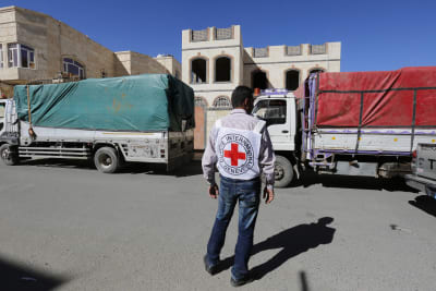 En biståndsarbetare för internationella Röda korset övervakar en biståndskonvoj i Sanaa.