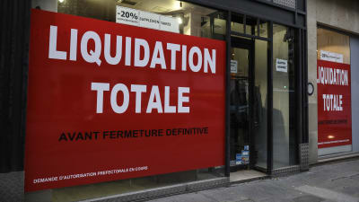 Skyltfönster täckta med blodröda anslag med texten "Liquidation totale".
