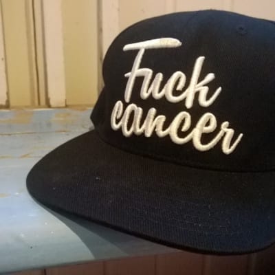 Lippis, jossa lukee Fuck Cancer.
