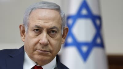 Benjamin Netanyahu framför en israelisk flagga