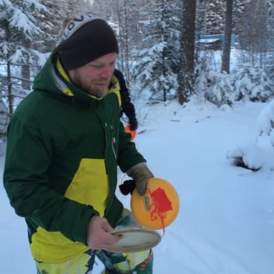 Mikko Pulkkinen ja frisbee talvisessa metsässä.