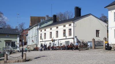 Folk sitter på en uteservering utanför Kaplansgården i Borgå.