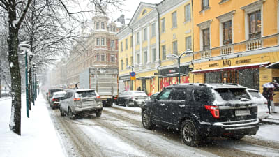 Bilar i snöfall på Norra Esplanaden i Helsingfors.
