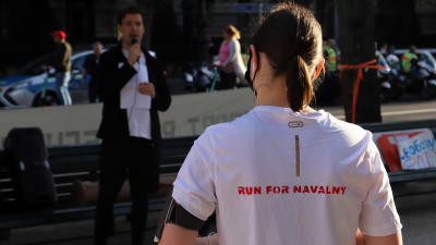 En kvinna som bär en tröja med texten "Run for Navalny" på ryggen