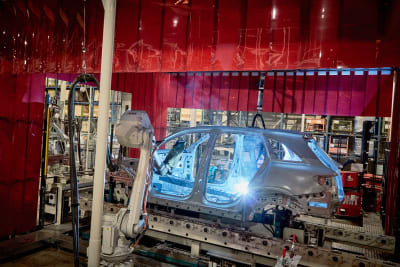 En robot bygger en bil i en fabrik. 