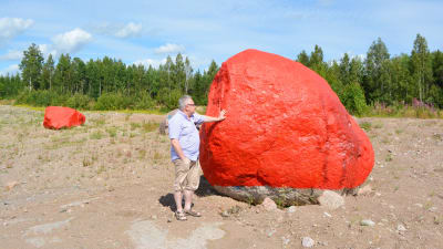 Ole Tjeder intill den första stenen som målades röd.
