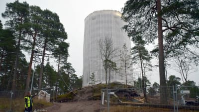 Karis vattentorn inpacketerat i plast. I nedre hörnet står vattenverkets direktör Klara Eklund.
