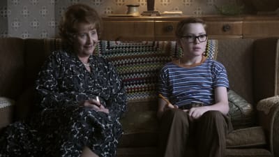 Ivy (Gemma Jones) sitter tillsammans med barnbarnet Reggie / Elton John (Kit Connor) i soffan.