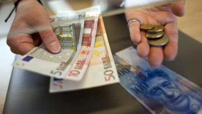 En kvinna växlar schweiziska frang till euro