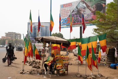 En flaggförsäljare med ett litet stånd vid en gata i Bamako i Mali säljer landets egna flaggor, men också ryska flaggor.