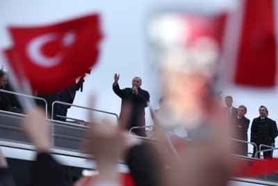 Erdogan talar till folket som viftar med Turkiets flaggor.