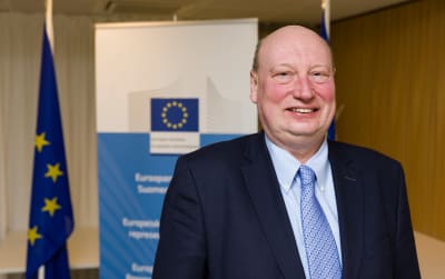 Henrik Hololei, högsta chef på EU-kommissionens trafikdepartement, skrattar i närbild. 