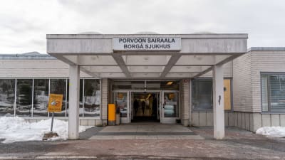 Ingång till vit, låg byggnad som det står "Borgå sjukhus" på. 