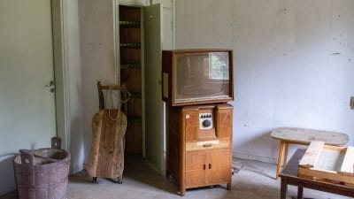 Gammaldags tv och möbler i ett rum.