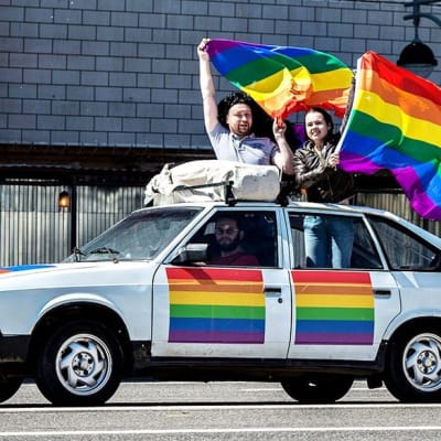Gayaktivister körde runt i en bil och viftade med regnbågsflaggan.