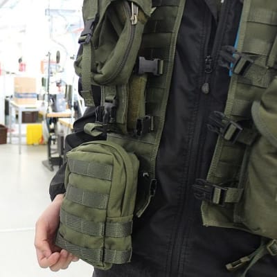 Taisteluliivi henkilön yllä Finn-Savotan tehtaalla.